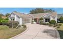 Welcoming home with well-maintained lawn and a spacious driveway leading to a two-car garage at 515 Torres Pl, Lady Lake, FL 32159