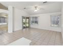 Bright living room with tile flooring, neutral walls, and a sliding glass door to the backyard at 515 Torres Pl, Lady Lake, FL 32159
