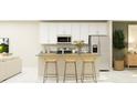 Modern kitchen with white cabinets, gray countertops, and breakfast bar at 7310 Ivy Tendril Ave, Orlando, FL 32829