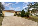 House with a white garage door and neatly landscaped front yard at 1504 Fort Meade Pl, Poinciana, FL 34759