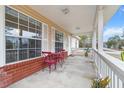 Covered porch with red chairs and plants, offering a relaxing outdoor space at 20 Hemlock Trl, Ocala, FL 34472