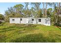 Gray mobile home on a grassy lot with a wooded backdrop at 2519 State Park Rd, Lakeland, FL 33805