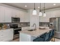 Modern kitchen with white cabinets, granite countertops, and stainless steel appliances at 6805 Sw 90Th Loop, Ocala, FL 34476