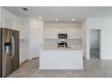 Modern kitchen with stainless steel appliances, quartz countertops, and a large island with a sink at 6805 Sw 90Th Loop, Ocala, FL 34476