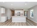 Bright, modern kitchen featuring white cabinets, stainless steel appliances, and an expansive center island at 6822 Sw 90Th Loop, Ocala, FL 34476