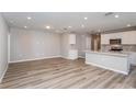 Spacious living area adjacent to a modern kitchen, featuring sleek floors and recessed lighting at 6822 Sw 90Th Loop, Ocala, FL 34476