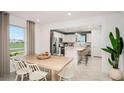 Open-concept dining room with a view to the bright kitchen, seamlessly connecting living spaces at 6825 Sw 90Th Loop, Ocala, FL 34476