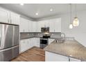 Modern kitchen with white cabinets, granite counters, and stainless steel appliances at 1509 Sweet Apple St, Oakland, FL 34787