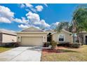 Tan house with a two-car garage and well-manicured lawn at 3723 Madbury Cir, Lakeland, FL 33810