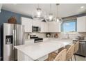 Bright kitchen featuring an island with seating, stainless steel appliances, and modern pendant lighting at 6788 Sw 90Th Loop, Ocala, FL 34476