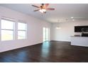 Spacious living room with dark hardwood floors and sliding glass doors at 430 Stillwater Ln, Haines City, FL 33844