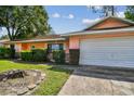 Charming single-story home with a well-manicured lawn and a two-car attached garage at 683 Anderson Dr, Deltona, FL 32725