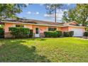 Charming single-story home with a well-manicured lawn and a two-car attached garage at 683 Anderson Dr, Deltona, FL 32725