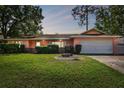 Charming single-story home with a well-manicured lawn and a two-car attached garage at 683 Anderson Dr, Deltona, FL 32725