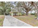 House exterior showcasing a long driveway and carport at 11730 Sw 230Th Avenue Rd, Dunnellon, FL 34431