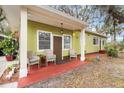 Inviting front porch with two wicker chairs and red flooring at 11730 Sw 230Th Avenue Rd, Dunnellon, FL 34431