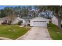 Single-story house with a two-car garage and landscaped yard at 1309 Ballesteros Dr, The Villages, FL 32162