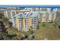 An aerial view showcasing a condo building's exterior, highlighting its location near a golf course and ocean at 4650 Links Village Dr # C703, Ponce Inlet, FL 32127