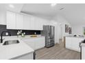 Modern kitchen featuring white cabinets, stainless steel appliances, and quartz countertops at 27100 Racquet Cir, Leesburg, FL 34748