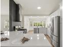 Modern kitchen with stainless steel appliances, white cabinets, quartz countertops, and a full backsplash at 27100 Racquet Cir, Leesburg, FL 34748