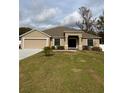 Tan house with a two-car garage and a well-maintained lawn at 2793 Hudson St, Lakeland, FL 33810