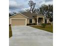 Tan house with a driveway and a lush green lawn at 2793 Hudson St, Lakeland, FL 33810