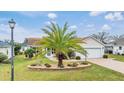 One-story home with a large palm tree in front at 3096 Lansing Way, The Villages, FL 32162