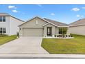 One story house with a two-car garage and well-manicured lawn at 8638 Triumph Cir, Wildwood, FL 34785