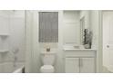 Clean bathroom with white vanity, tub shower combo, and gray accents at 4192 Singing Mockingbird Blvd, Bartow, FL 33830