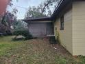 Rear view of a tan house with brown trim and a screened porch at 112 Jasper St, Bushnell, FL 33513