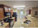 Kitchen with granite countertops, dark wood cabinets, and black appliances at 2157 Geneva Dr, Lakeland, FL 33805