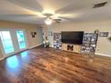 Bright living room featuring wood floors, ceiling fan, and French doors to the backyard at 2157 Geneva Dr, Lakeland, FL 33805