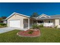 House exterior showcasing a garage and well-manicured lawn at 10984 Sw 81St Ave, Ocala, FL 34481