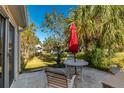 Relaxing patio with table, chairs, and red umbrella, overlooking backyard at 10984 Sw 81St Ave, Ocala, FL 34481