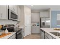 Modern kitchen with gray cabinets, stainless steel appliances, and white countertops at 5782 Meditation Dr, Clermont, FL 34714