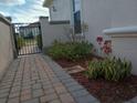 Brick walkway and landscaping with lush greenery along the home's side at 2491 Harwich Dr, Kissimmee, FL 34741