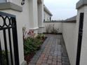 Landscaped side yard with brick walkway and wrought-iron gate at 2491 Harwich Dr, Kissimmee, FL 34741