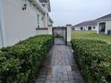 Brick pathway leads to a private gated entrance at 2491 Harwich Dr, Kissimmee, FL 34741