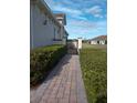 Brick walkway leads to private gated entry with manicured hedges at 2491 Harwich Dr, Kissimmee, FL 34741