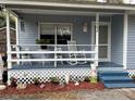 Charming front porch with rocking chair and decor, complemented by well-maintained landscaping at 1268 Cr 436, Lake Panasoffkee, FL 33538