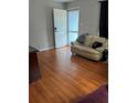 Cozy living room with wood floors and a comfortable sofa next to a bright, open doorway at 1268 Cr 436, Lake Panasoffkee, FL 33538