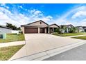 Two-car garage home with a long driveway and landscaping at 2954 Flying Blackbird Rd, Bartow, FL 33830