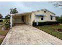 Front view of a yellow house with a carport and landscaping at 3109 Sand Trap Ct, Lakeland, FL 33810