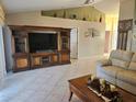 Living room with large TV stand, comfy couch, and tile floors at 619 Parakeet Ct, Kissimmee, FL 34759