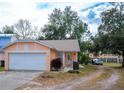 Attractive light peach house with a white garage door at 1100 Lowry Ave # 7, Lakeland, FL 33801