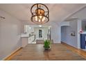 Open-concept dining room showcasing a modern light fixture, wood floors, and an inviting view into the kitchen at 1412 E Main St, Lakeland, FL 33801