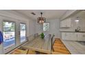 Bright dining room with hardwood floors, stylish light fixture, and a view of the deck through glass doors at 1412 E Main St, Lakeland, FL 33801
