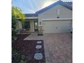 Home boasts a brick driveway, manicured landscaping, and a convenient two-car garage at 4035 Solamor St, Lakeland, FL 33810