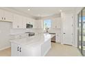 Modern kitchen features sleek white cabinets, stainless steel appliances, and a spacious island with marble countertops at 5915 Sw 87Th Ave, Ocala, FL 34481