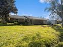 Brick ranch house with a large front yard and landscaping at 5040 Kirkland Rd, Lakeland, FL 33811